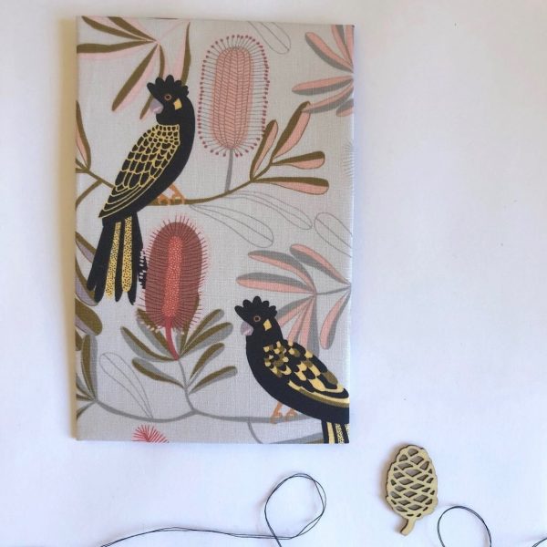 A neutral coloured handkerchief featuring Yellow-tailed Black-Cockatoos and banksia trees.