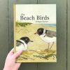 The front cover of 'The Beach Birds' by Bridget Farmer. Features an illustration of two Hooded Plovers on a sandy beach.