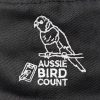 A close up of the Aussie Bird Count logo on the black bucket hat. The logo features a rainbow lorikeet sitting on a branch above 'Aussie Bird Count', adjacent to a small electronic device with a feather in front of it.