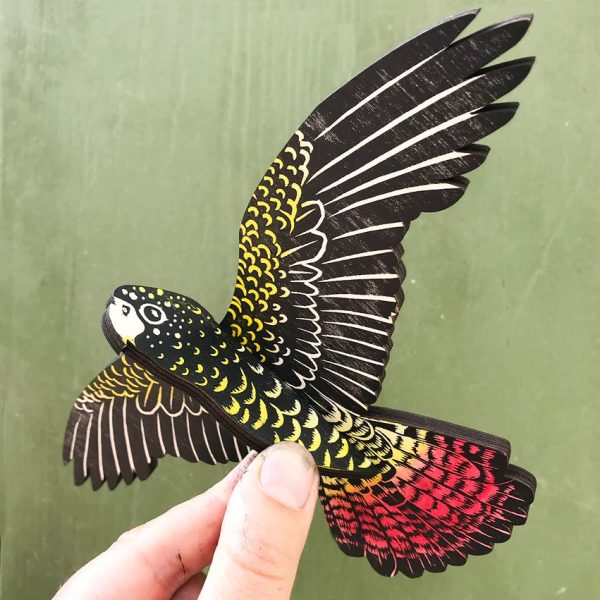 A female Red-tailed Black-Cockatoo mobile on a green background.