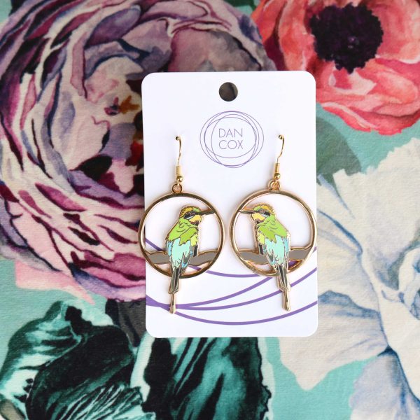 Two circular earrings displayed on a card, sitting on top of a colourful floral background. The earrings feature a Rainbow Bee-eater sitting on a branch.