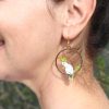 A Sulphur-crested Cockatoo earring hanging from the left ear of a person.
