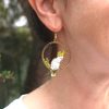 A Sulphur-crested Cockatoo earring hanging from the right ear of a person.