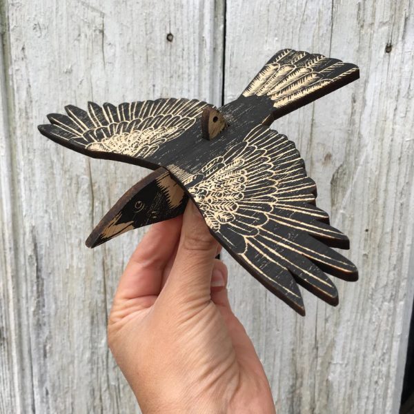 An assembled wooden mobile of an Australian Magpie, held in the hand.